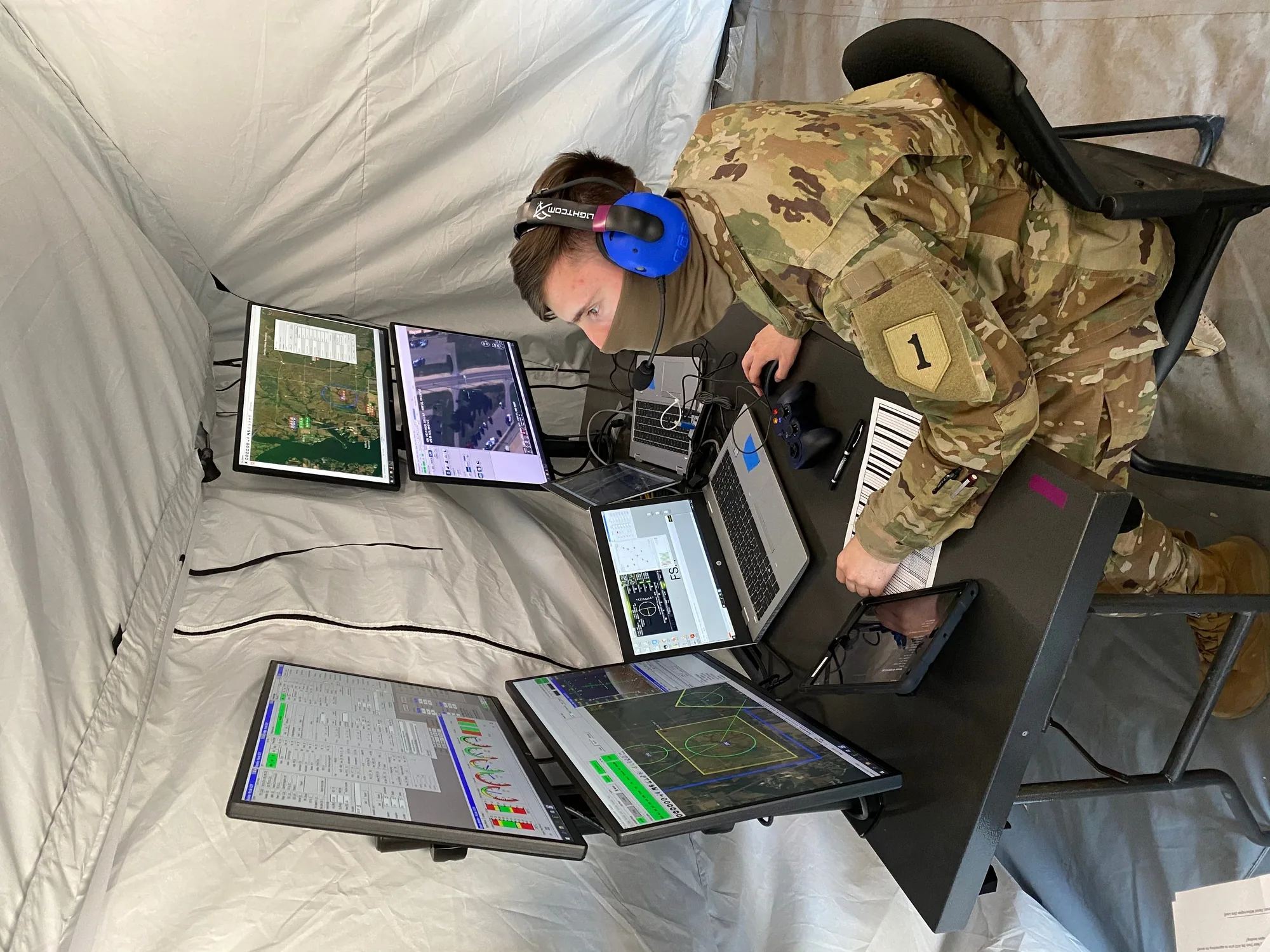 A soldier operates a laptop-based ground control station during an unmanned aircraft assessment