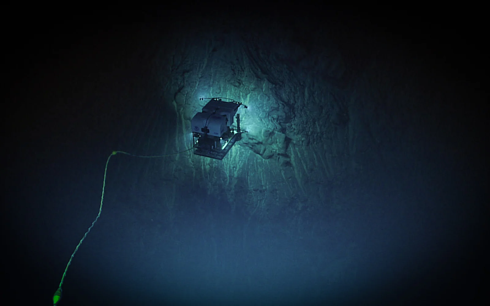 NOAA remotely operated vehicle Deep Discoverer illuminating a rocky seafloor during a 2025 dive 4,755 meters below the surface